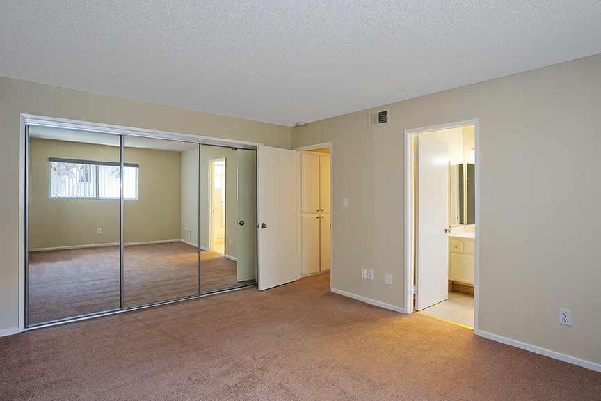 an empty living room with a large mirror